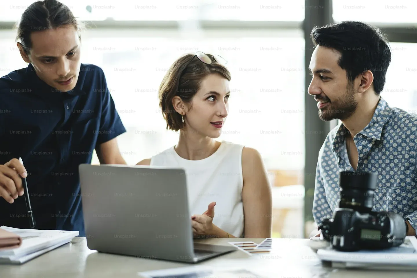 Business team meeting around a laptop in an office