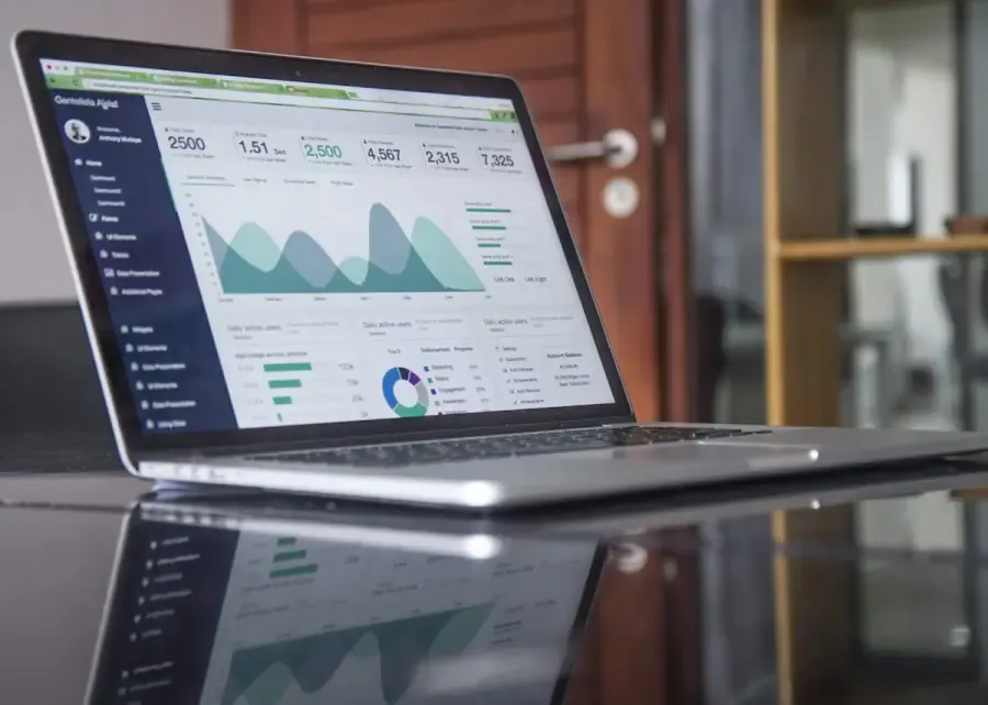 A business owner reviewing monthly management accounts on a laptop, comparing actual performance against budget to identify cash flow trends and plan the next quarter